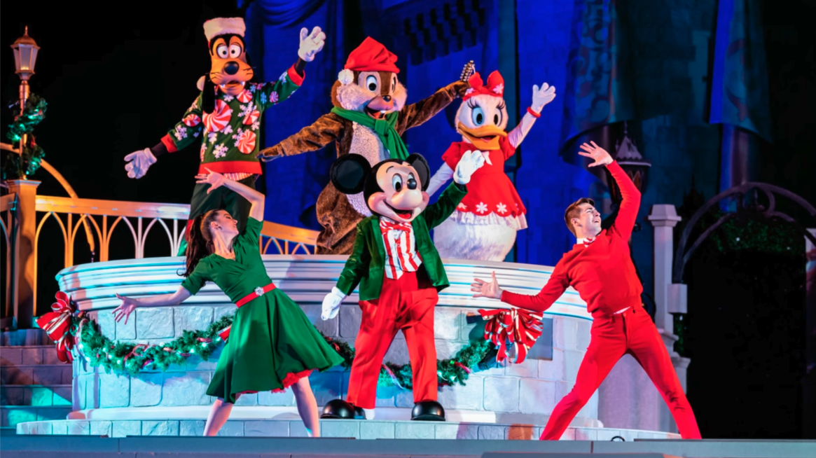 mickey and friends in christmas outfits on a stage